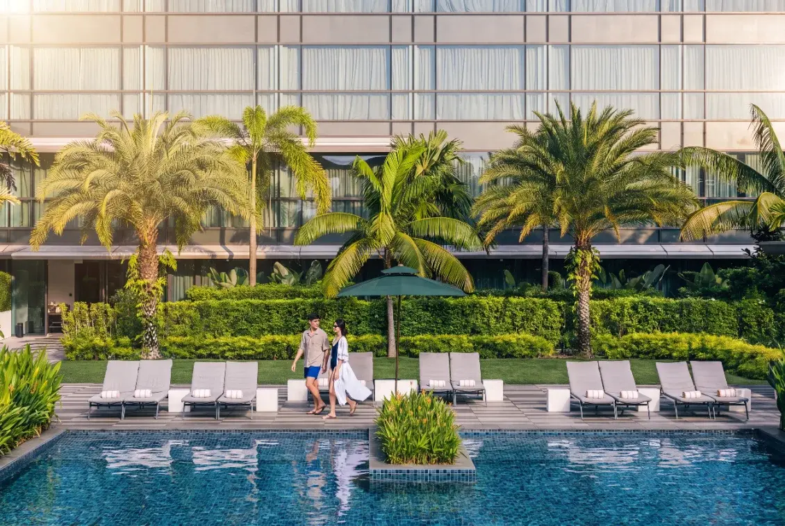 Resort pool framed by tropical planting at Dusit Thani Laguna Singapore