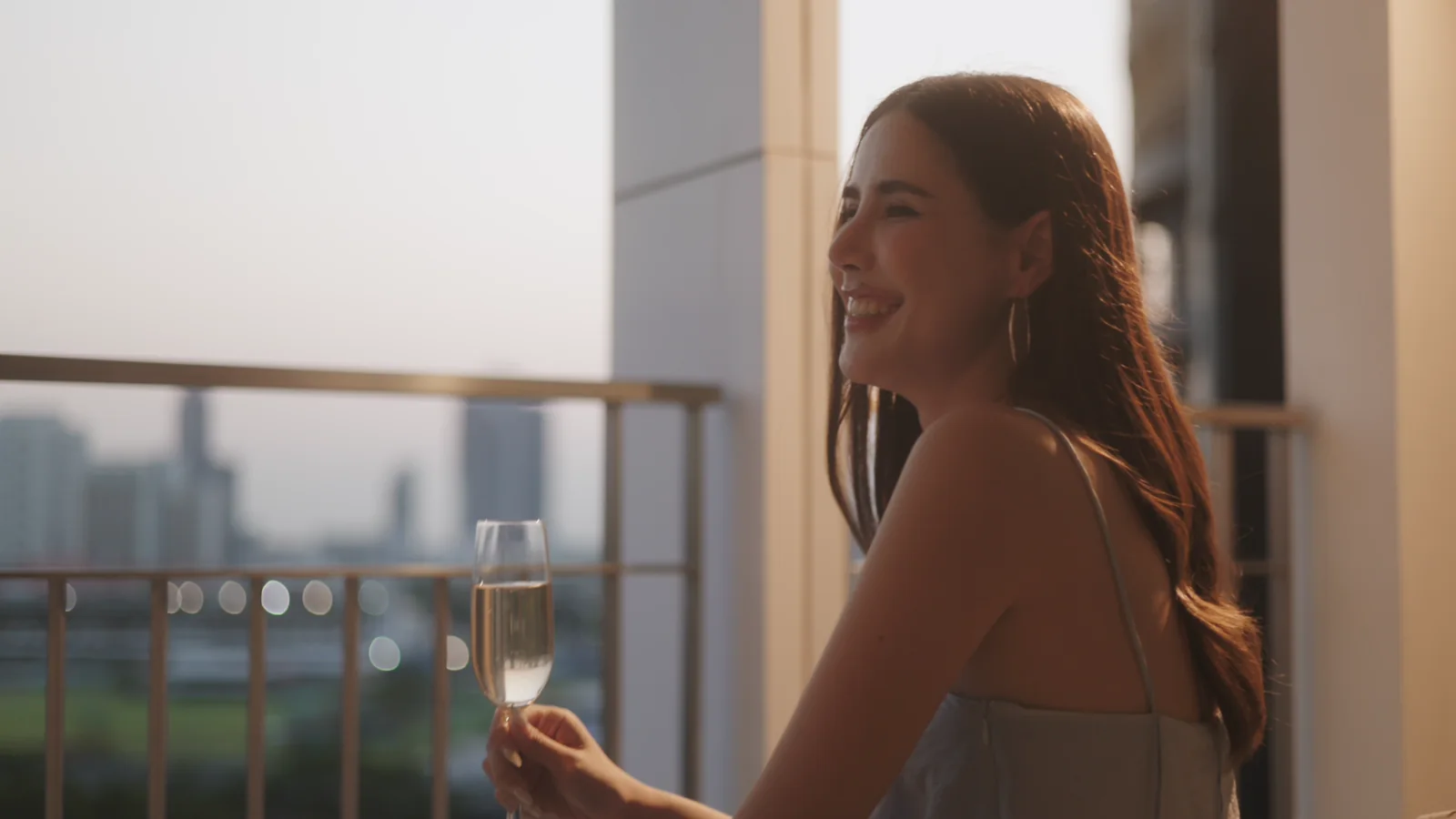 Guest enjoying a sunset balcony moment at Dusit Suites Ratchadamri Bangkok